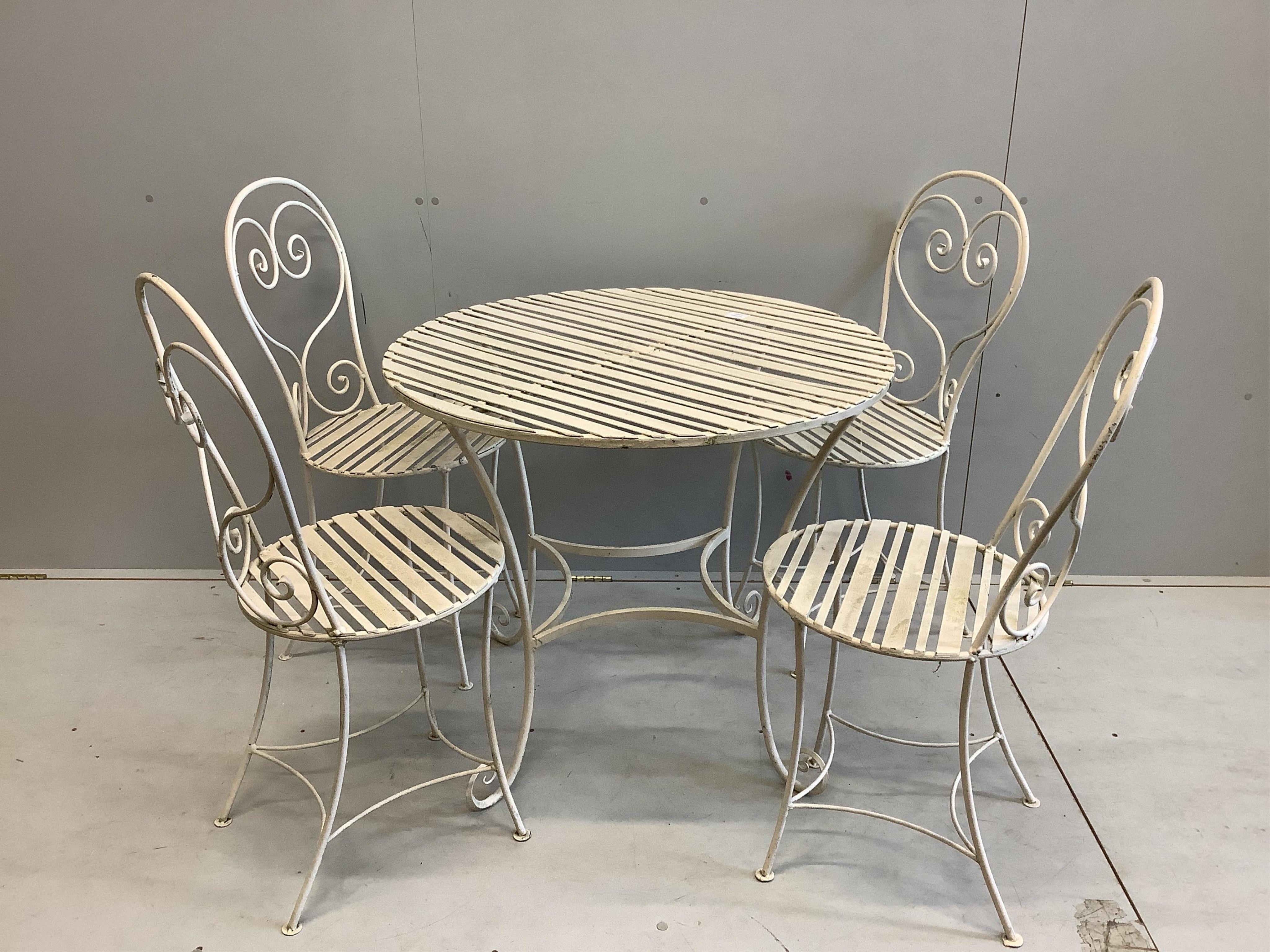 A Camelia Botnar circular wrought iron garden table, diameter 88cm, height 74cm together with four chairs with seat pads. Condition - fair